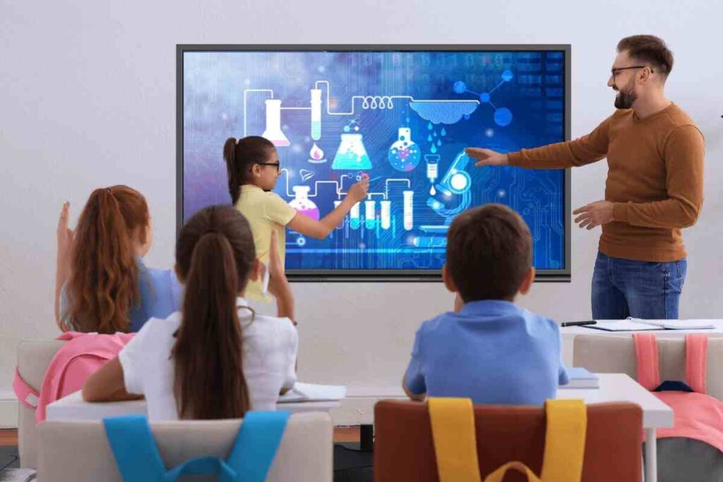 Group of Students studying in classroom using interactive flat panel display
