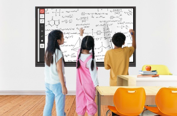 Three students using interactive whiteboard in classroom