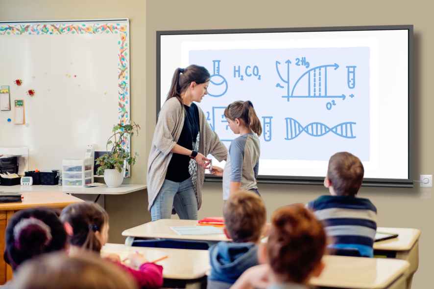 Group of Students studying in classroom teacher and student using interactive flat panel display
