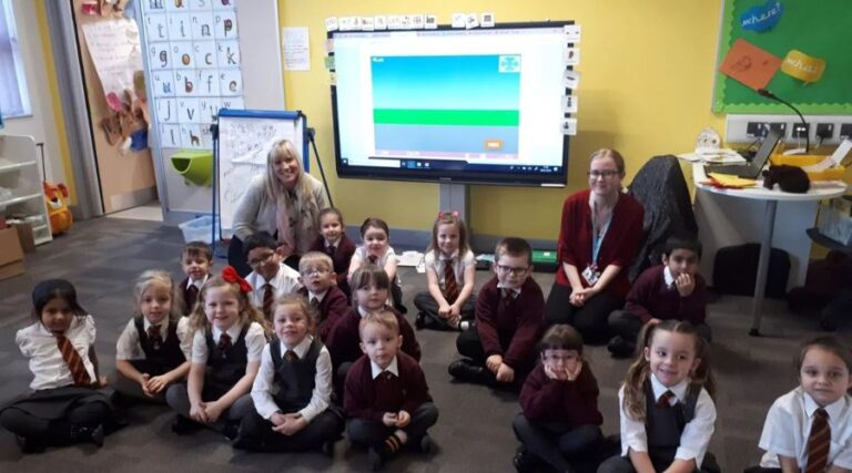 teachers and students sit on floor in the classroom