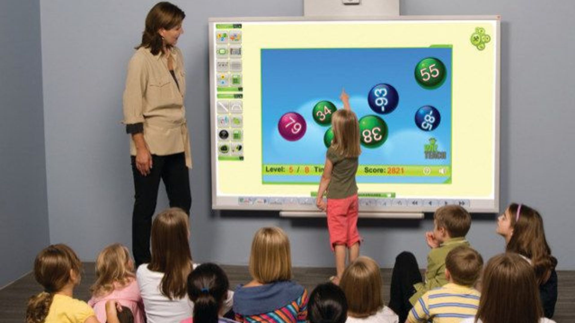 Teacher and students work on interactive flat panel display in classroom